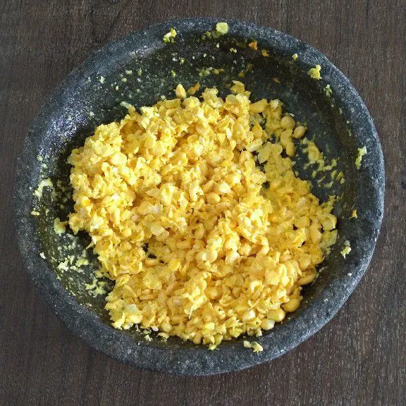 Haluskan jagung dan bawang putih, bawang merah, kunyit, dan cabe rawit.