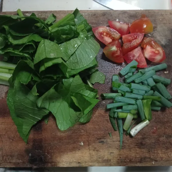 Potong potong caisim, tomat, dan daun bawang.