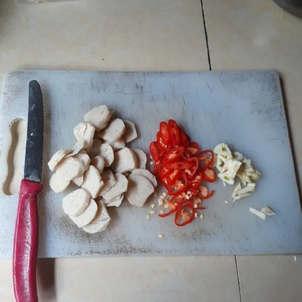 Cincang bawang putih. Iris tipis cabai dan bakso.