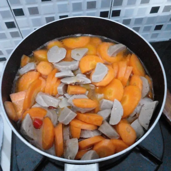 Masukkan wortel dan bakso. Tambahkan air, gula dan garam kemudian masak hingga matang.