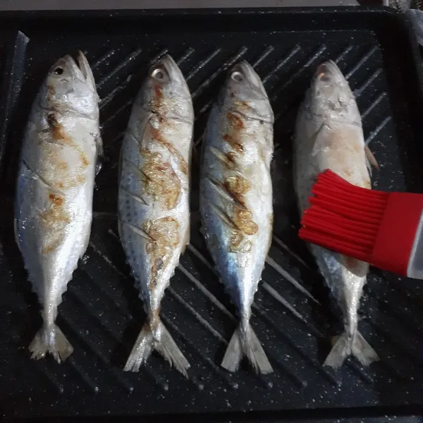 Oles panggangan dengan sedikit minyak dan panaskan dengan api sedang. Lalu panggang ikan hingga matang sambil sesekali dioles dengan minyak sayur. Sisihkan.