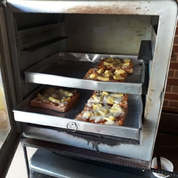 Panggang dalam oven yang sudah dipanaskan, gunakan api sedang hingga matang. Bagian bawah roti agak kecoklatan dan keju meleleh. Enak disajikan selagi panas.