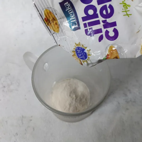 Masukkan gula pasir dan bubuk krimer ke dalam gelas.