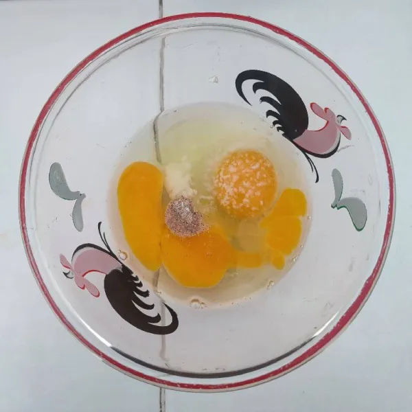 Pecahkan telur, bumbui dengan garam, merica bubuk, kaldu jamur dan bawang putih bubuk. Kocok lepas.