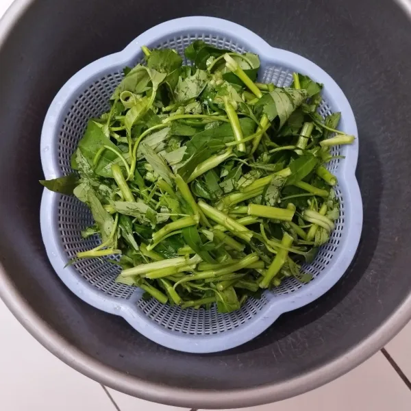 Siangi kangkung, lalu potong sesuai selera. Rendam dengan air garam selama 5 menit. Cuci bersih lalu bilas dan tiriskan.