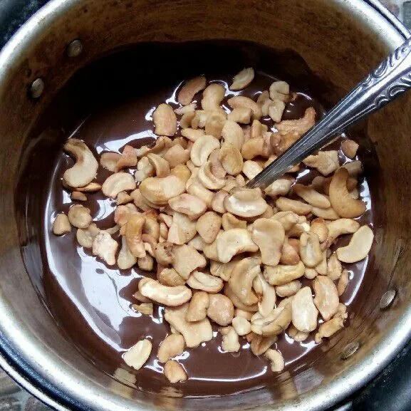 Masukkan kacang mede ke dalam lelehan coklat.