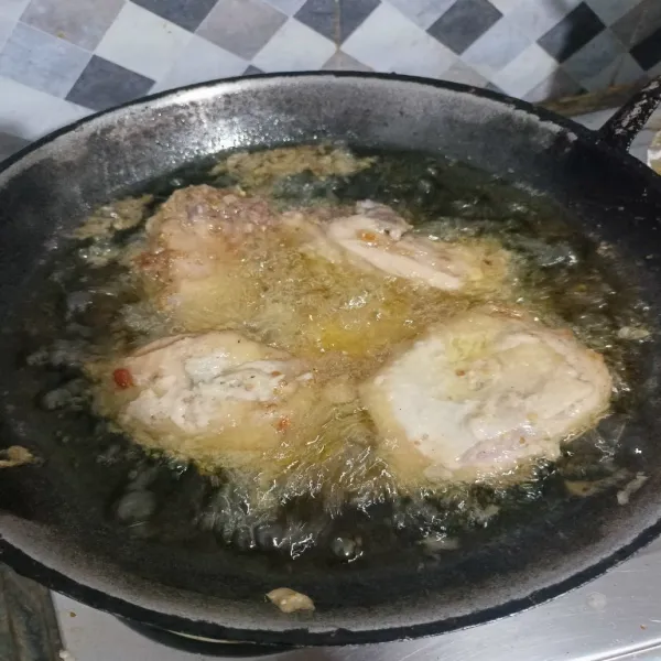 Goreng ayam dalam minyak panas.