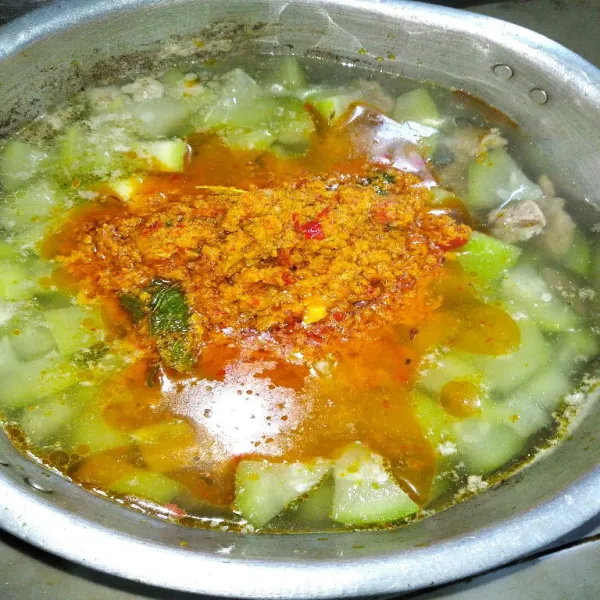 Masukkan bumbu ke dalam labu putih, beri garam, kaldu bubuk dan gula.