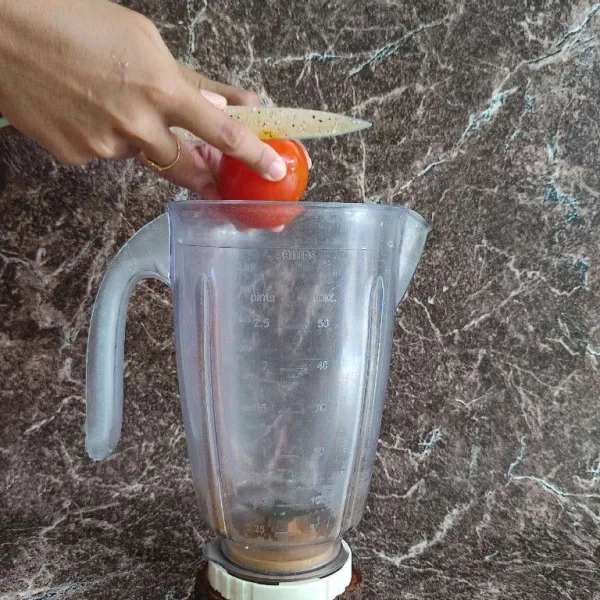 Potong-potong tomat, masukkan ke dalam blender.