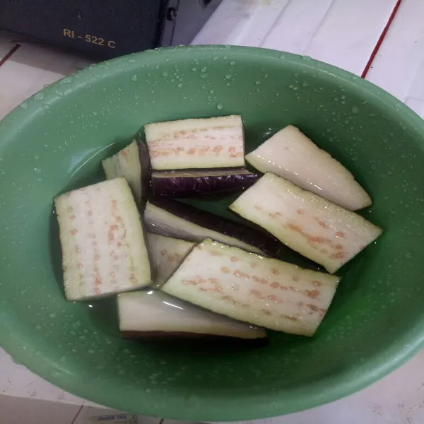 Potong terong beberapa bagian lalu belah dua, cuci bersih dan tiriskan.