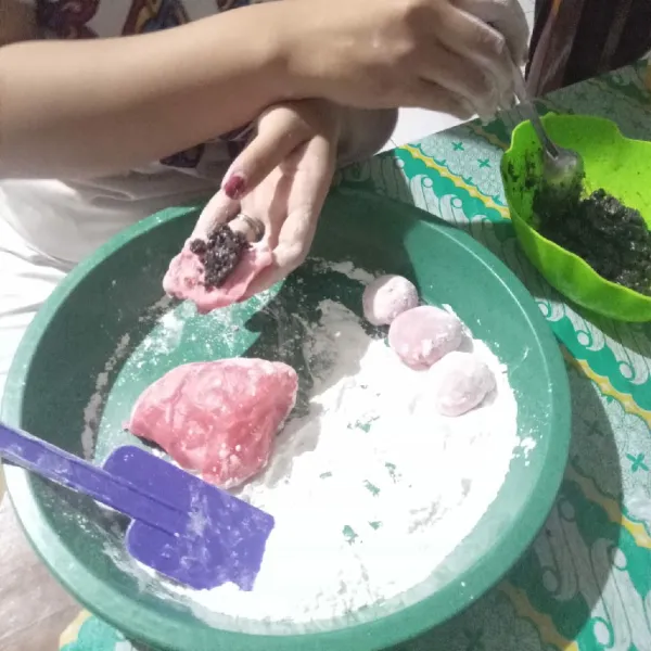 Potong adonan sesuai selera, pipihkan dan tambahkan isian biskuit coklat secukupnya, bulatkan dan lumuri lagi dengan tepung yang sudah di sangrai, lakukan hingga adonan habis.