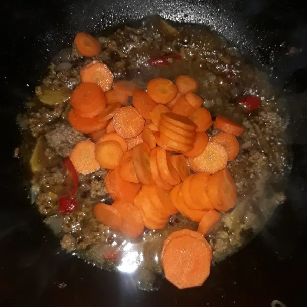 Masukkan wortel, aduk-aduk sampai layu.
