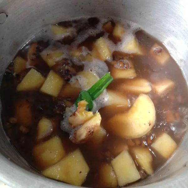 Masukkan singkong, ubi, jahe, dan daun pandan ke dalam rebusan kacang hijau. Masak sampai singkong dan ubi lunak.