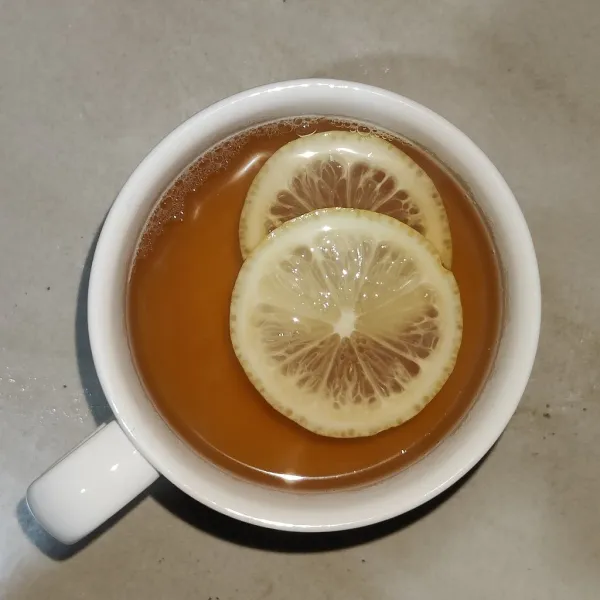 Tuang ke gelas saji, beri perasan dan irisan jeruk lemon