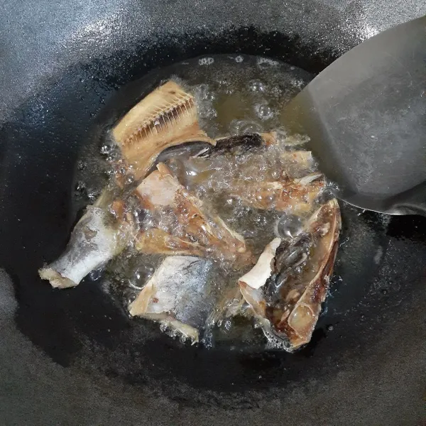 Cuci bersih ikan asin baung, potong-potong dan goreng hingga garing dengan api sedang. Sisihkan.