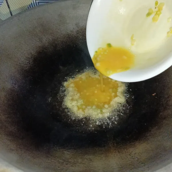 Panaskan minyak goreng diwajan sampai benar-benar panas, lalu tuang telur.
