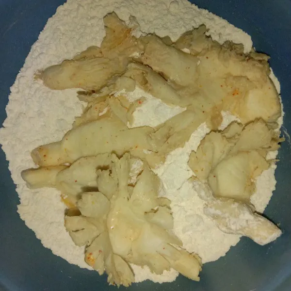 Masukkan jamur tiram ke wadah tepung kering, baluri sambil ditekan pelan agar tepungnya menempel dengan sempurna.