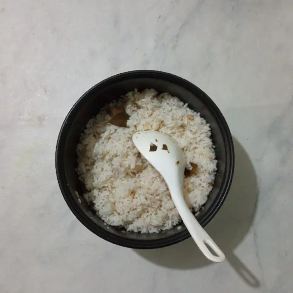 Setelah matang, aduk nasi liwet. Beri taburan bawang goreng. Siap disajikan bersama bahan pelengkapnya.