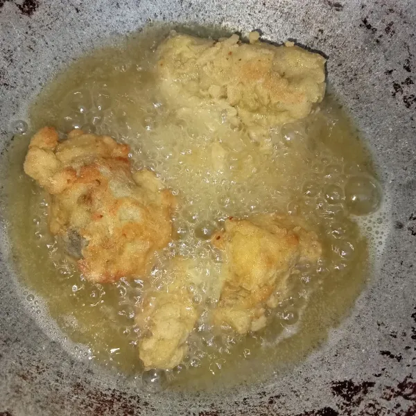 Panaskan minyak kemudian masukkan ayam dan goreng hingga kering kuning keemasan angkat dan tiriskan.