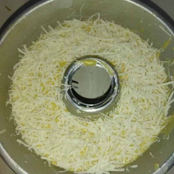 Siapkan loyang sudah dioles karlo, saya pakai loyang tulban diameter 18 cm, lalu tuang adonan ke loyang, lalu hentakan loyang nya, lalu beri topping keju cheddar parut.