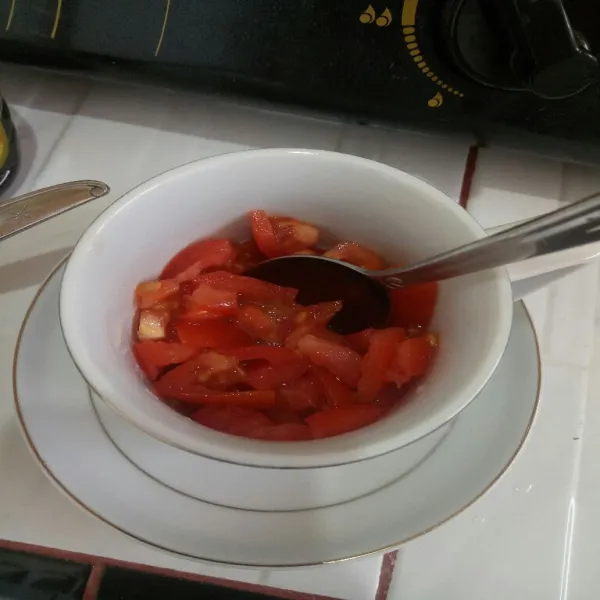 Dalam gelas hancurkan buah tomat pake sendok.