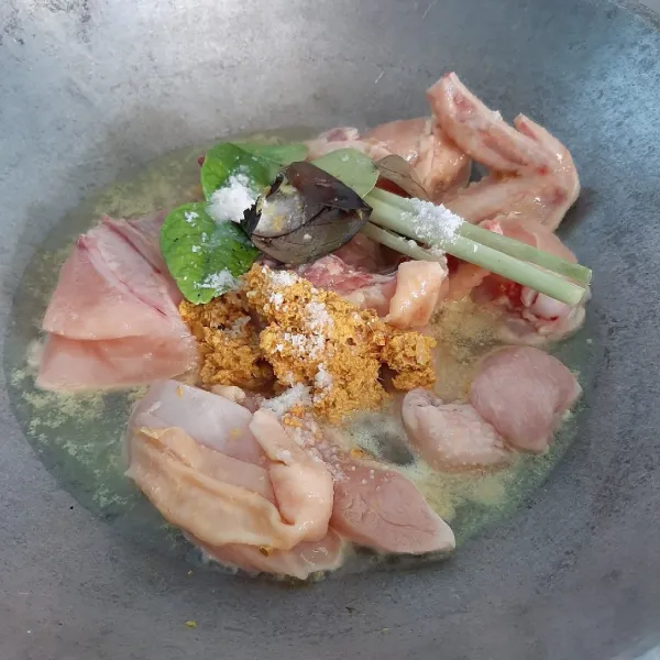 Dalam wajan atau panci masukkan ayam, bumbu halus, serai geprek, daun jeruk dan daun salam. Tambahkan garam dan air secukupnya.