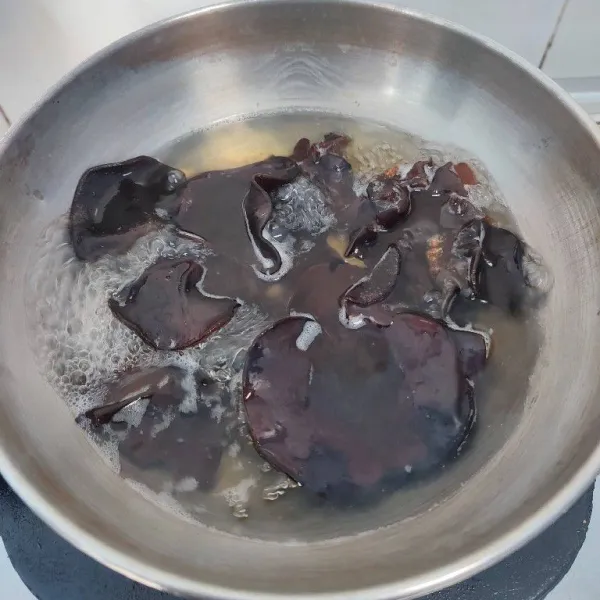 Rendam jamur kuping dengan air garam selama 5 menit. Kemudian rebus hingga mendidih, tiriskan dan potong-potong. Sisihkan.