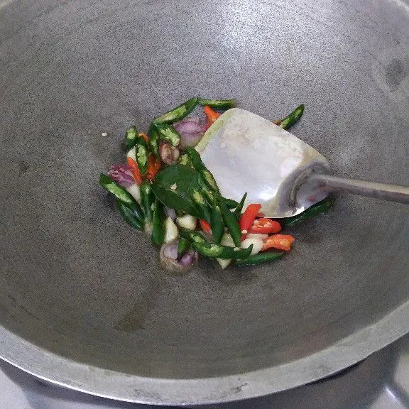 Tumis bumbu iris dan daun jeruk hingga aromanya harum dan tanak.