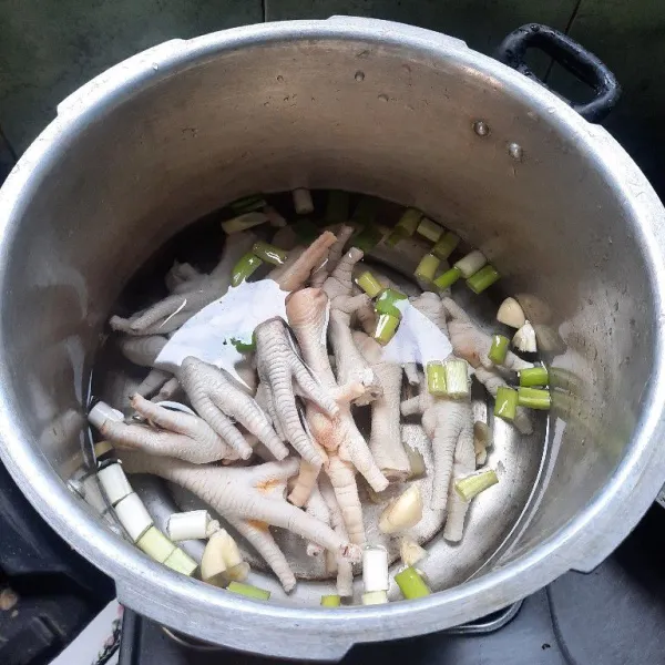 Masukan ceker ayam lalu masak dalam panci presto sampai empuk.