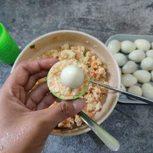 Masukkan adonan tahu ke dalam cup kemudian beri telur puyuh di tengahnya.