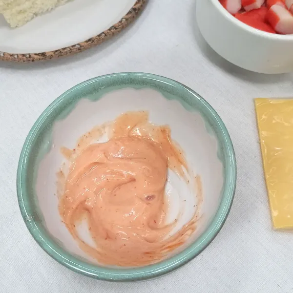 Campur mayonnaise dan saos sambal tomat dalam wadah.