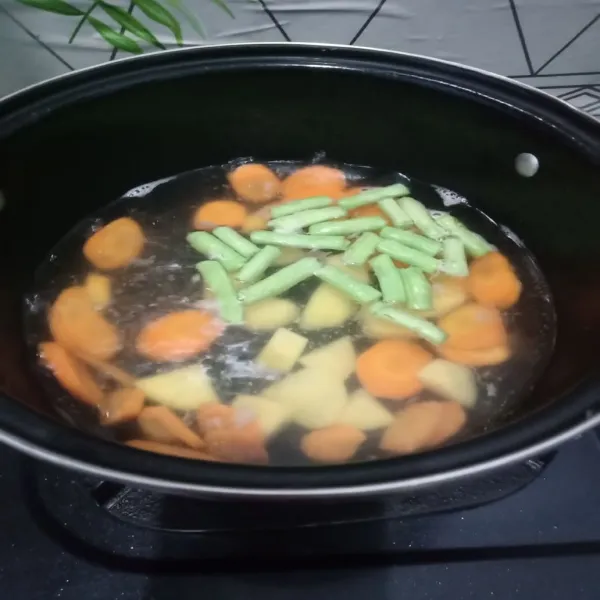 Masukkan wortel, buncis dan kentang rebus setengah matang.