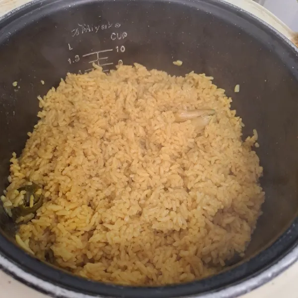 Jika tombol magic com sudah pada posisi warm, segera aduk rata nasi. Kemudian tutup kembali sekitar 10 menit. Nasi kuning siap disajikan dengan pelengkapnya.