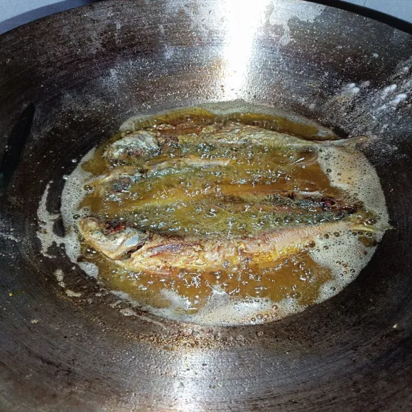 Beri 1 sdm taburan tepung di atas minyak, lalu goreng ikan kembung yang sudah dimarinasi. Fungsi taburan agar tidak lengket.