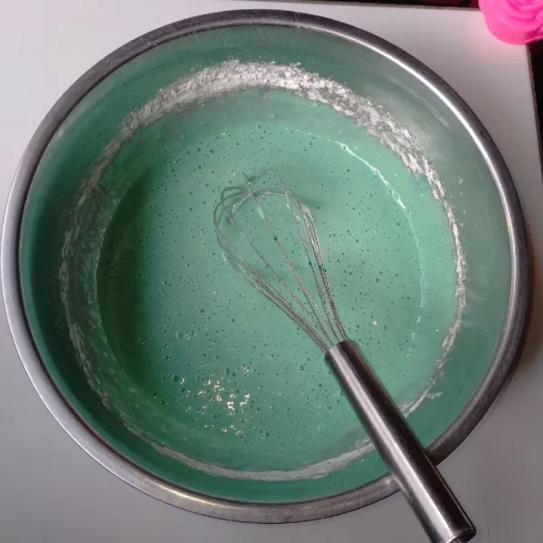 Masukkan tepung terigu berganti-gantian dengan larutan santan bunga telang. Aduk balik hingga rata.
