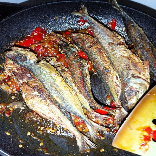 Aduk merata ikan goreng di atas pan berisi sambal. Matikan kompor. Cukup diaduk merata saja ya.