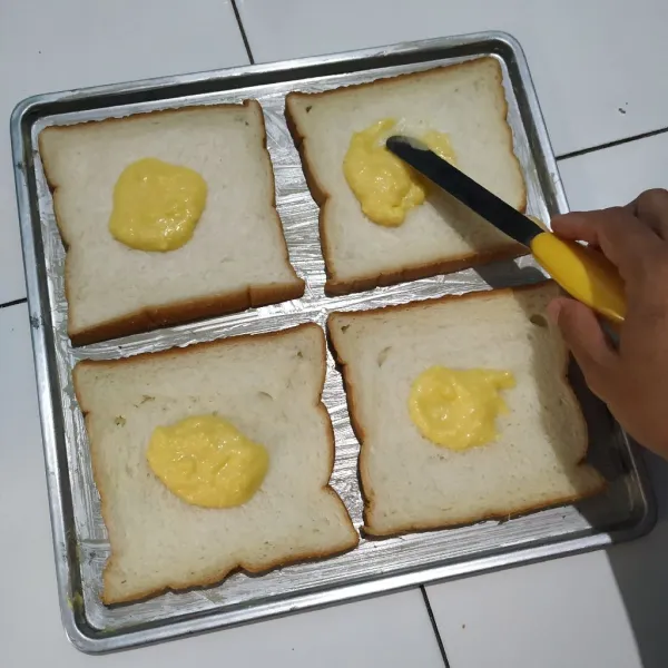 Susun roti di atas loyang lalu olesi bagian atas roti dengan campuran susu kental manis dan butter margarin.