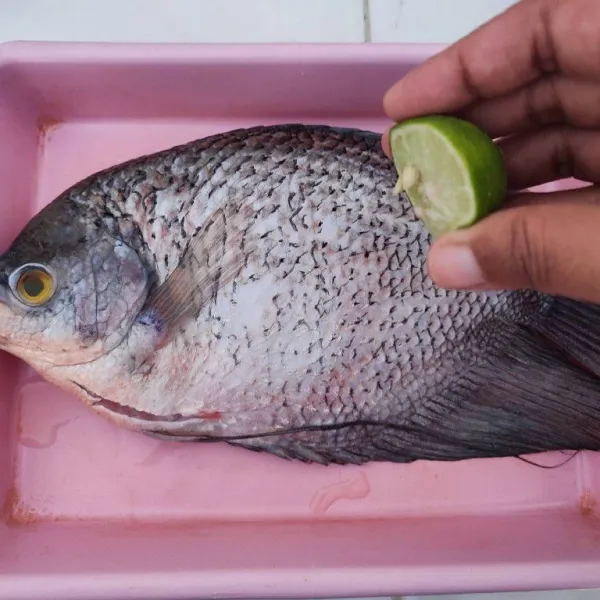 Bersihkan ikan, beri perasan jeruk nipis, ratakan. Kemudian balur dengan garam, ratakan. Diamkan selama 15 menit.