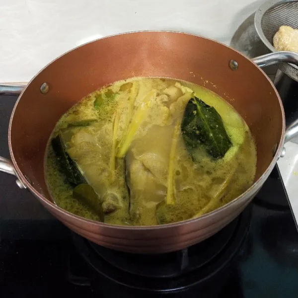 Masukkan tumisan bumbu ke dalam rebusan ayam. Tambahkan garam, kaldu bubuk dan gula.