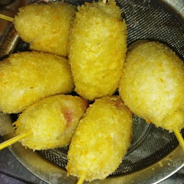 Angkat, biarkan corndog dingin, simpan dalam wadah tertutup, taruh di kulkas, goreng lagi corndog ketika akan disajikan.