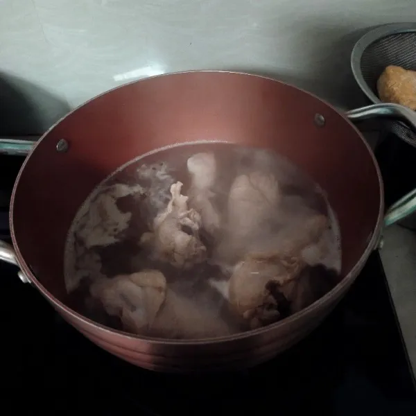 Masak air hingga mendidih lalu masukkan ayam, rebus hingga ayam matang.