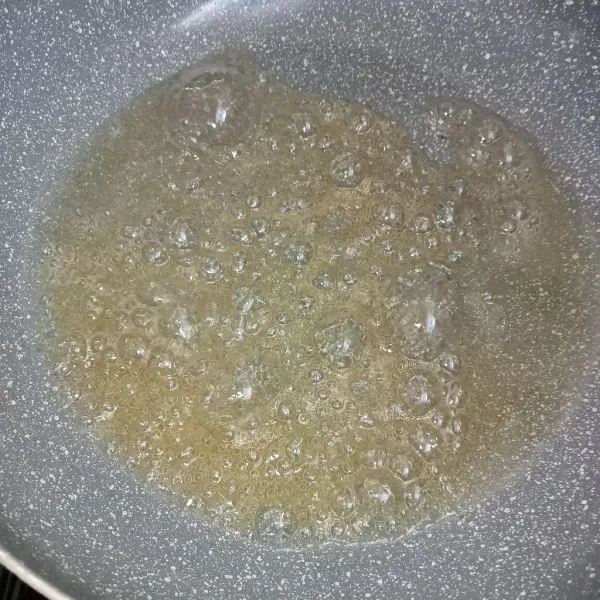 Campur gula dan air didalam teflon kemudian masak hingga gula mendidih.