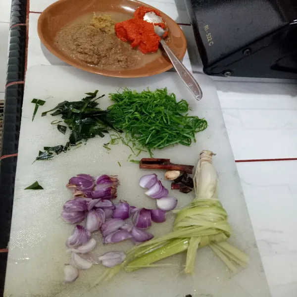 Siapkan bahan lalu Iris daun kunyit, daun jeruk dan bawang merah. Geprek serei, blender bumbu hingga halus.