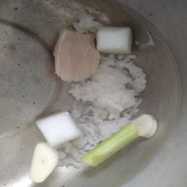 Masukkan ayam, labu, serai, nasi dan bawang putih, lalu rebus hingga empuk.