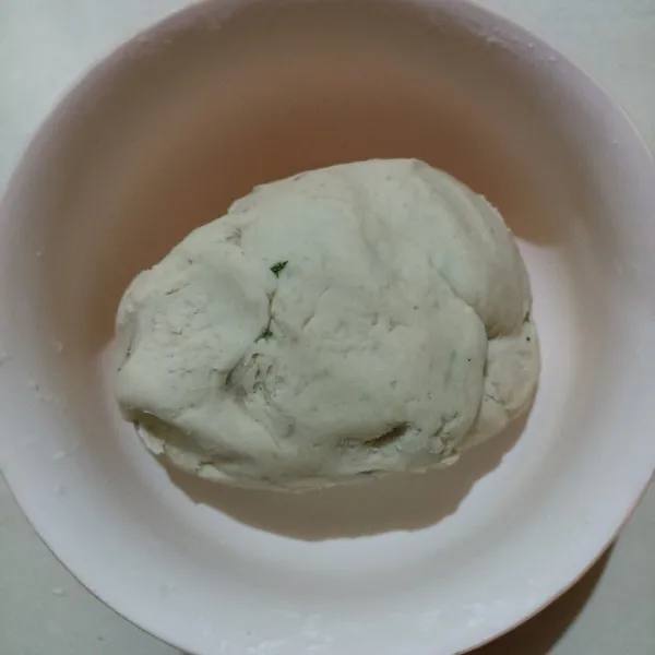 Setelah adonan hangat, masukkan tepung tapioka, uleni merata sampai kalis.