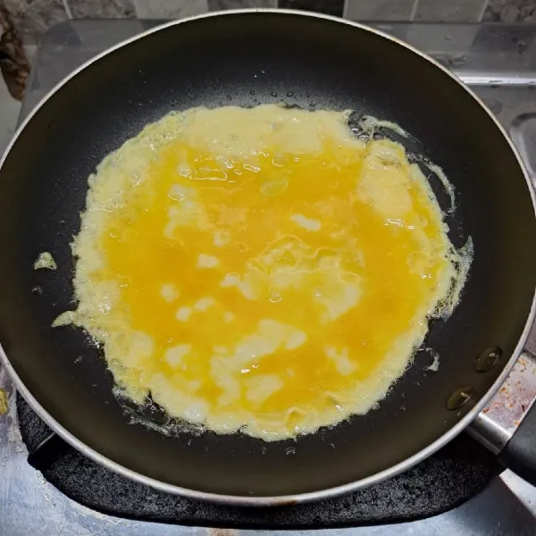 Panaskan teflon dengan sedikit minyak goreng. Kemudian tuang adonan telur.