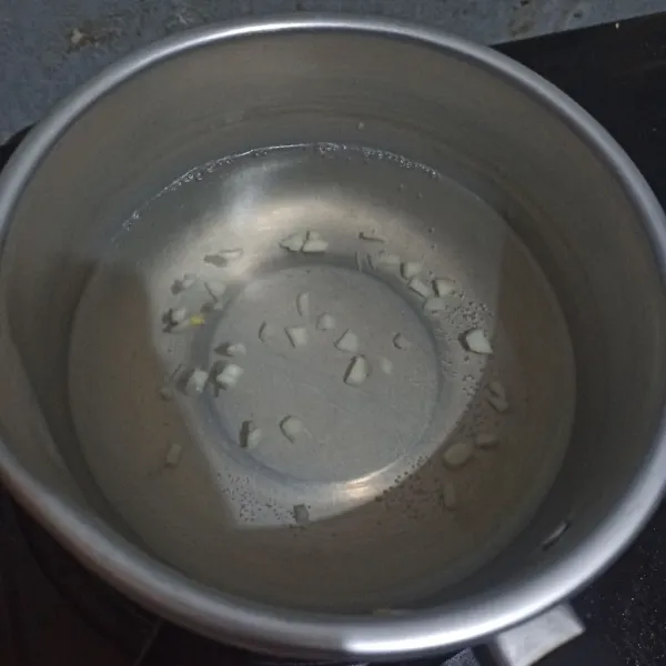Didihkan air di panci. Saat mulai panas masukkan bawang putih cincang.