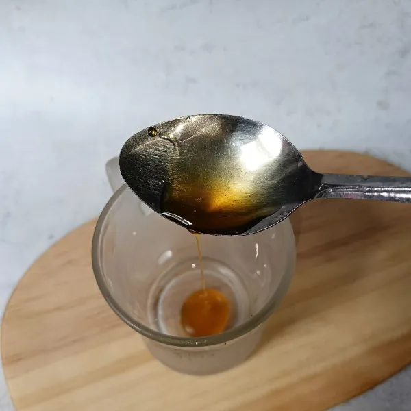 Siapkan gelas dan masukkan madu.