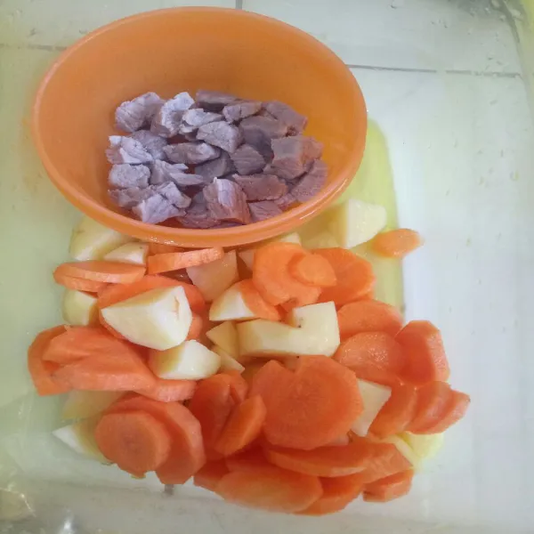 Cuci bersih daging, potong dadu daging, lalu presto sekitar 5 menit. Potong kentang dan wortel sisihkan.
