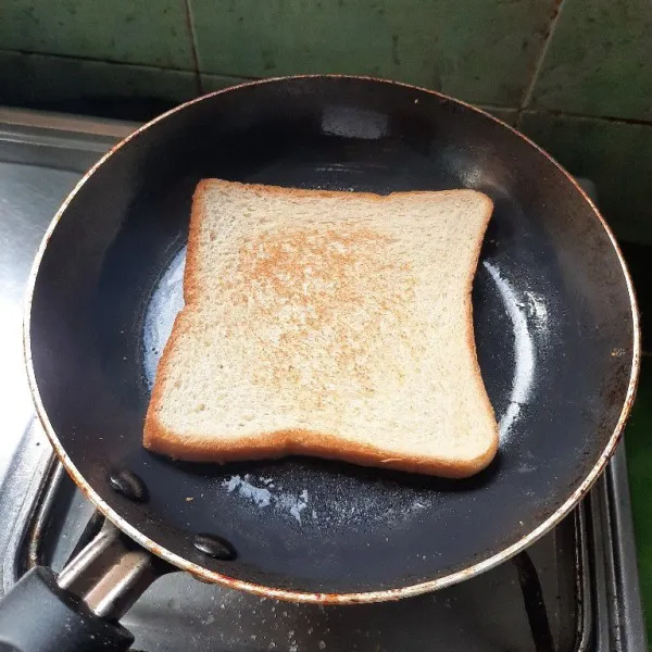 Panggang roti di atas teflon yang sudah diberi mentega.